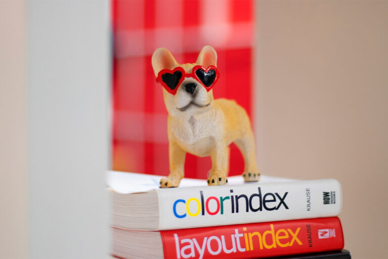 dog figurine with sunglasses on stack of books