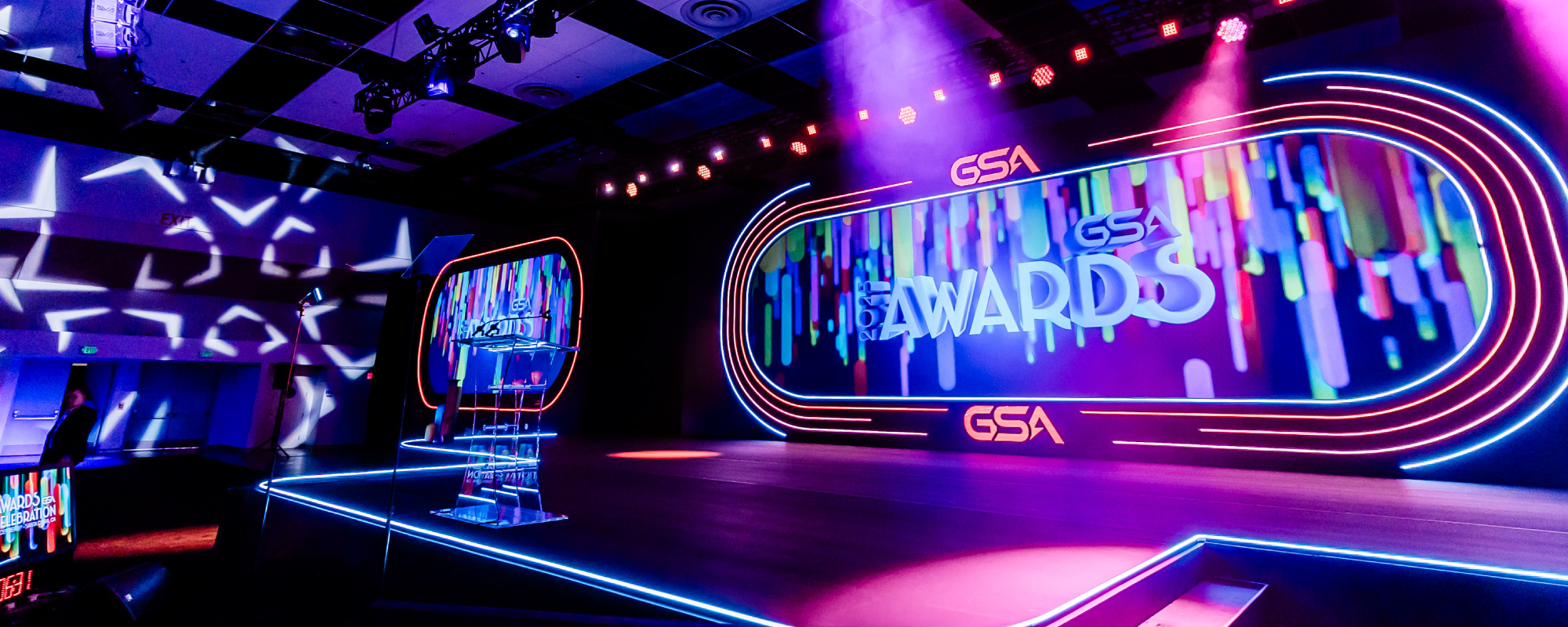 Event stage with the 2025 GSA Awards Celebration branding on a number of video screens