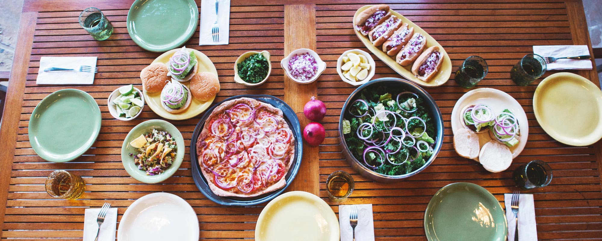 Overhead photo of kitchen table with various dishes featuring fresh produce
